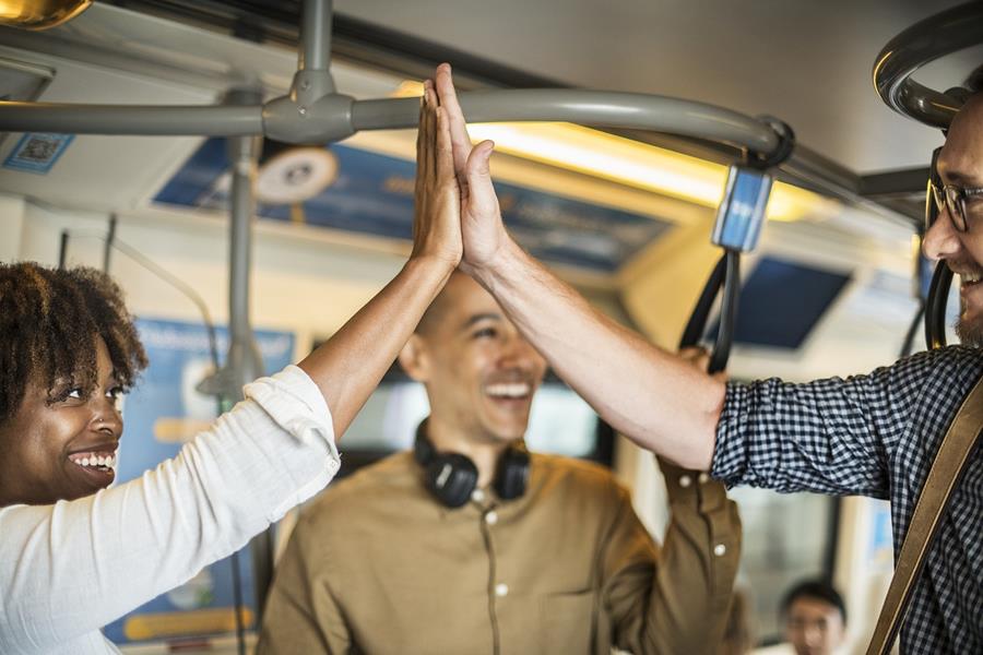 Friends giving a high-five on a bus