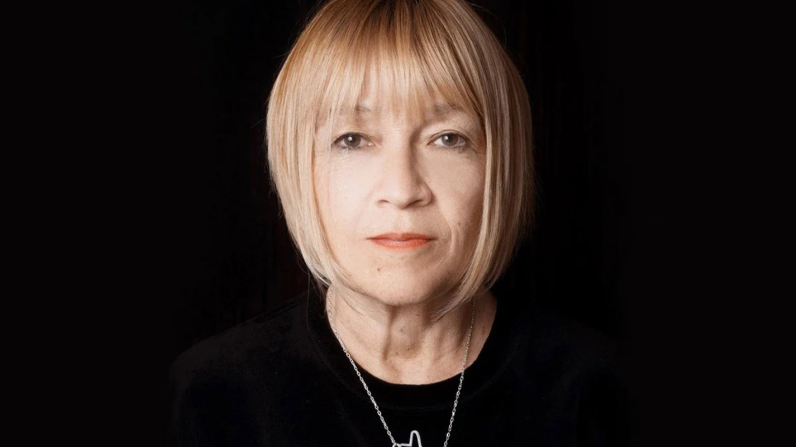 Confident woman with short blond bob staring straight ahead at camera