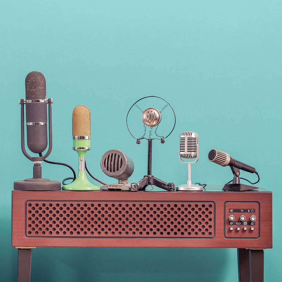 old radio with several old-fashioned microphones on blue background