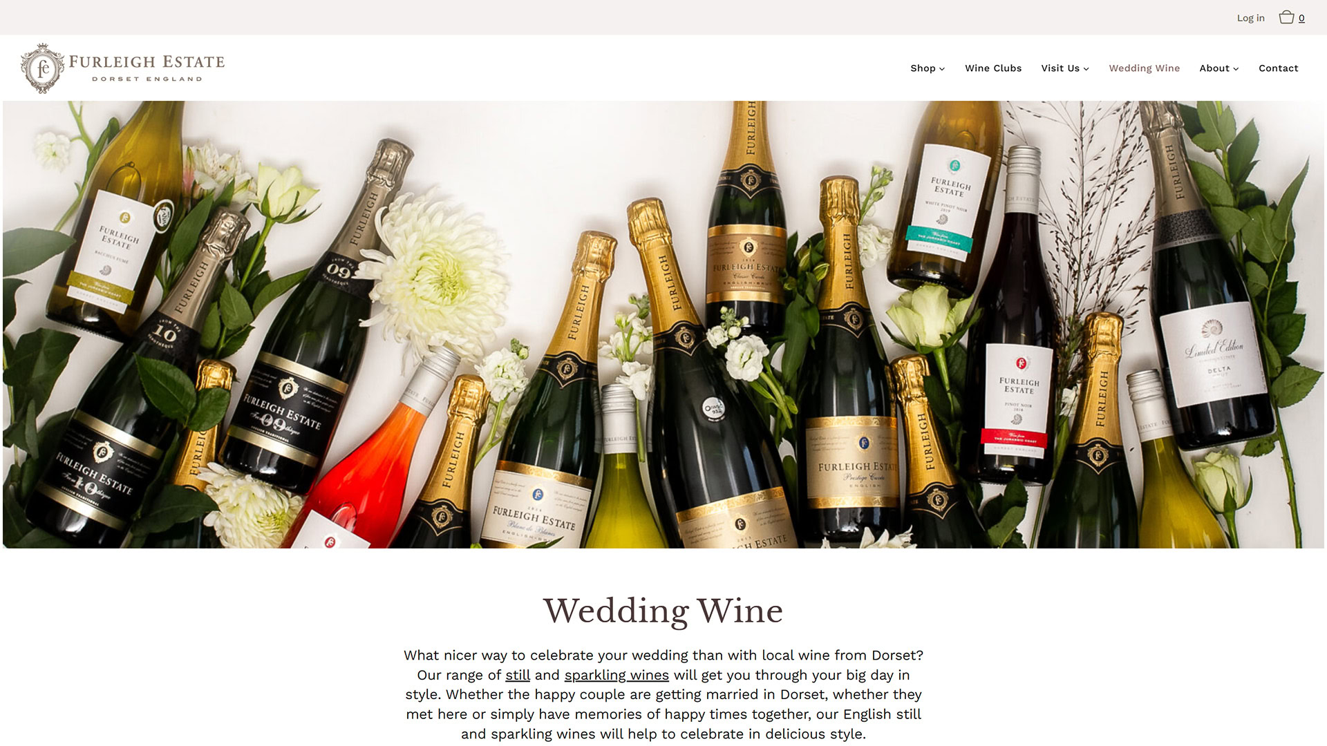 An assortment of Furleigh Estate sparkling and still wine bottles arranged with fresh white flowers and greenery on a white background, featured on the winery’s Wedding Wine page.