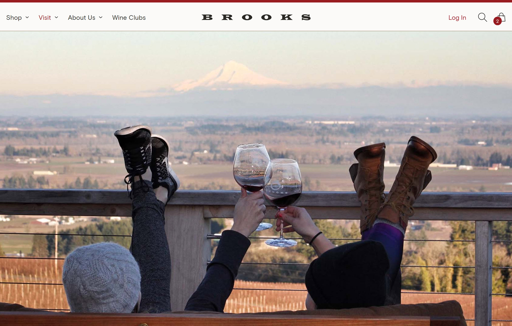 Two friends sit on the Brooks upstairs patio, overlooking the mountains and drinking wine