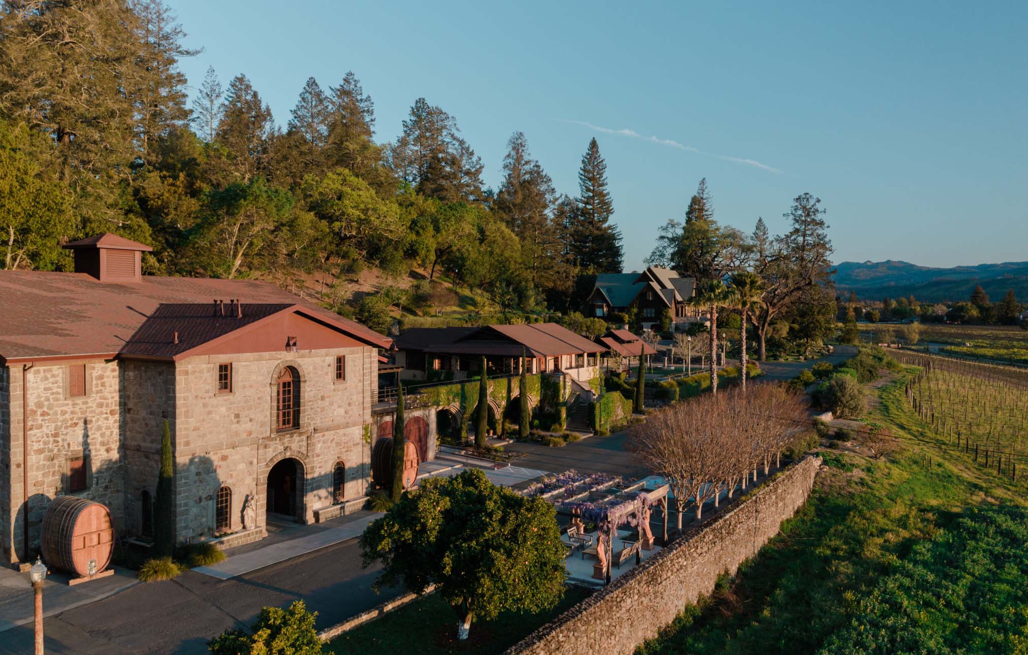 Aerial View of a large stone winery and tasting room facility surrounded by lush vineyards