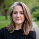 Woman with long brown hair photographed in front of park setting