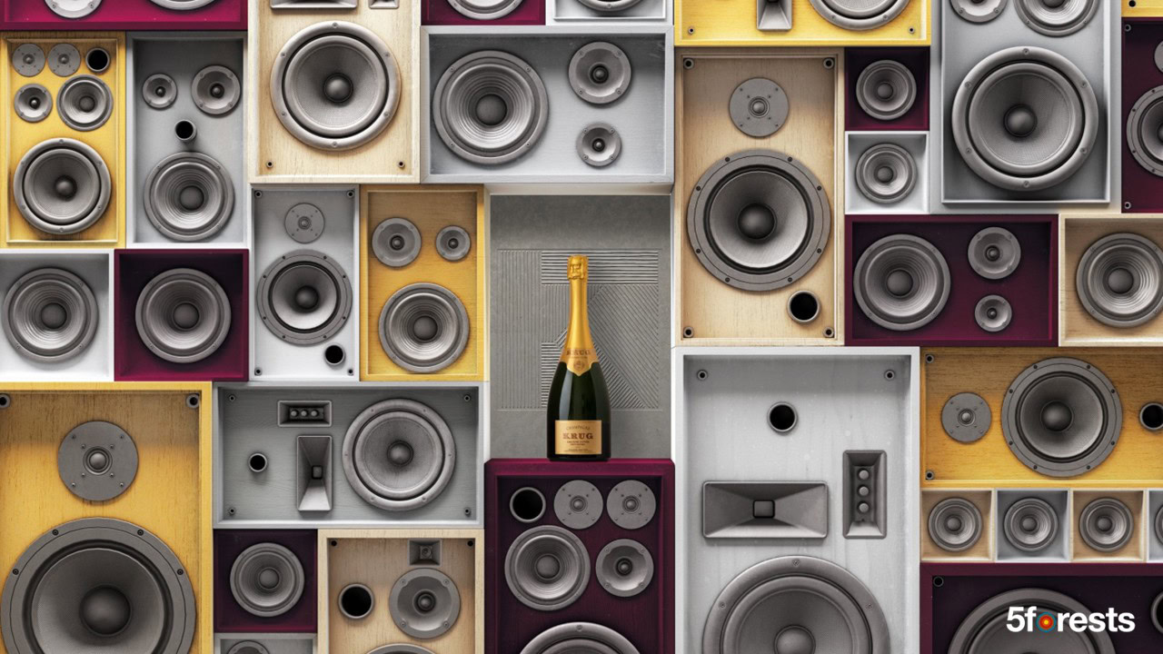 A wall of variously sized and colored speakers with a single bottle of champagne placed in the center.