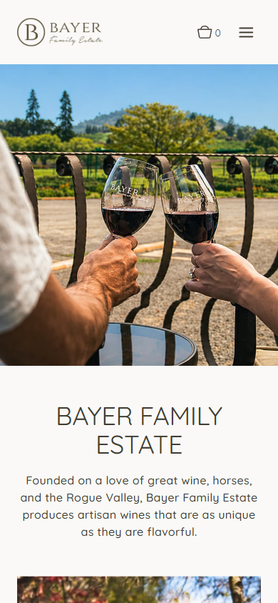 The Bayer Family Estate homepage on a phone, with the photograph of two people touching glasses of red wine above the winery name and introduction.