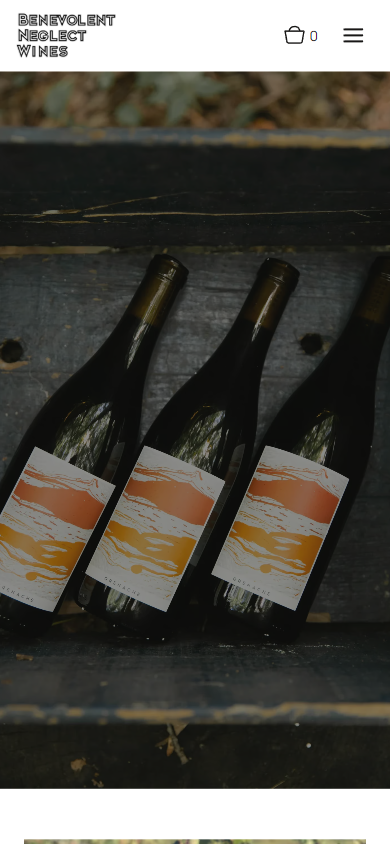 The Benevolent Neglect homepage on a phone, with the three labeled bottles laid out on the weathered boards.