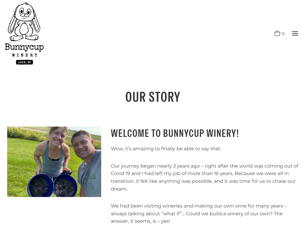 The Bunnycup About page in a desktop browser, headed "Our Story", with a photograph of the owners holding glasses on the lawn beside the account of how the winery began.
