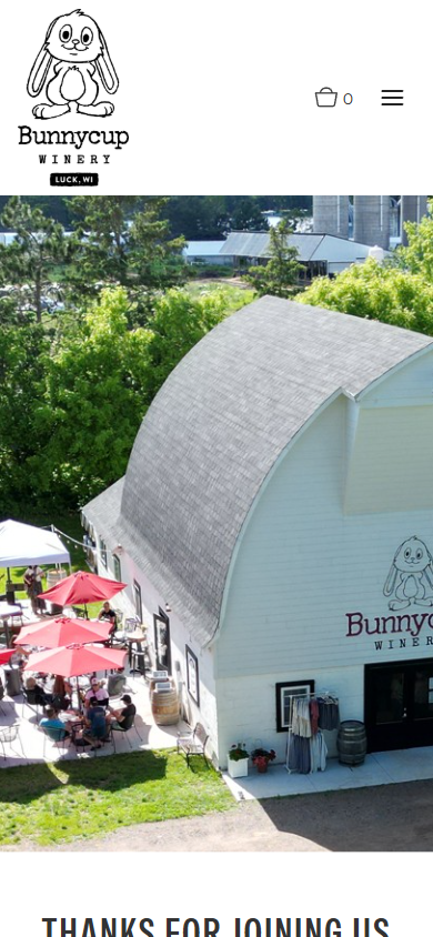 The Bunnycup homepage on a phone, with the barn and busy patio above a thank you to visitors.