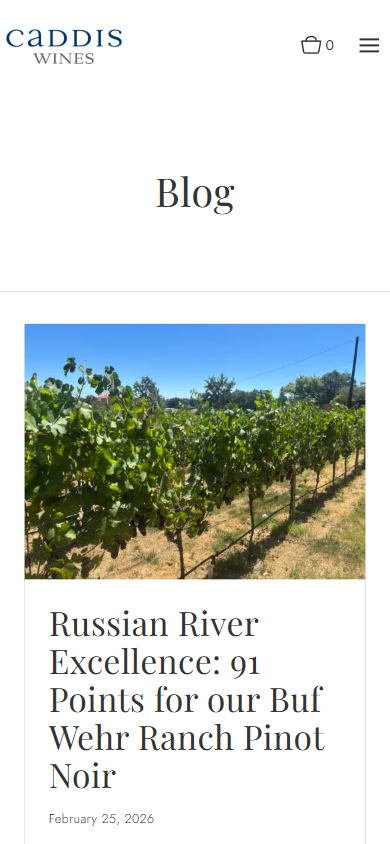 The Caddis Wines blog on a phone, showing a vineyard photograph above a post about a 91-point score for a Russian River pinot noir.