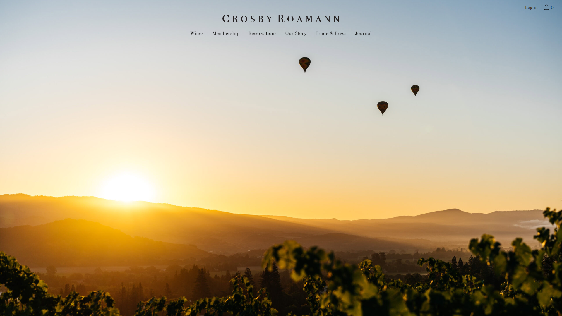 The Crosby Roamann wines page in a desktop browser, with the sun rising over the hills and three hot air balloons above the vines.