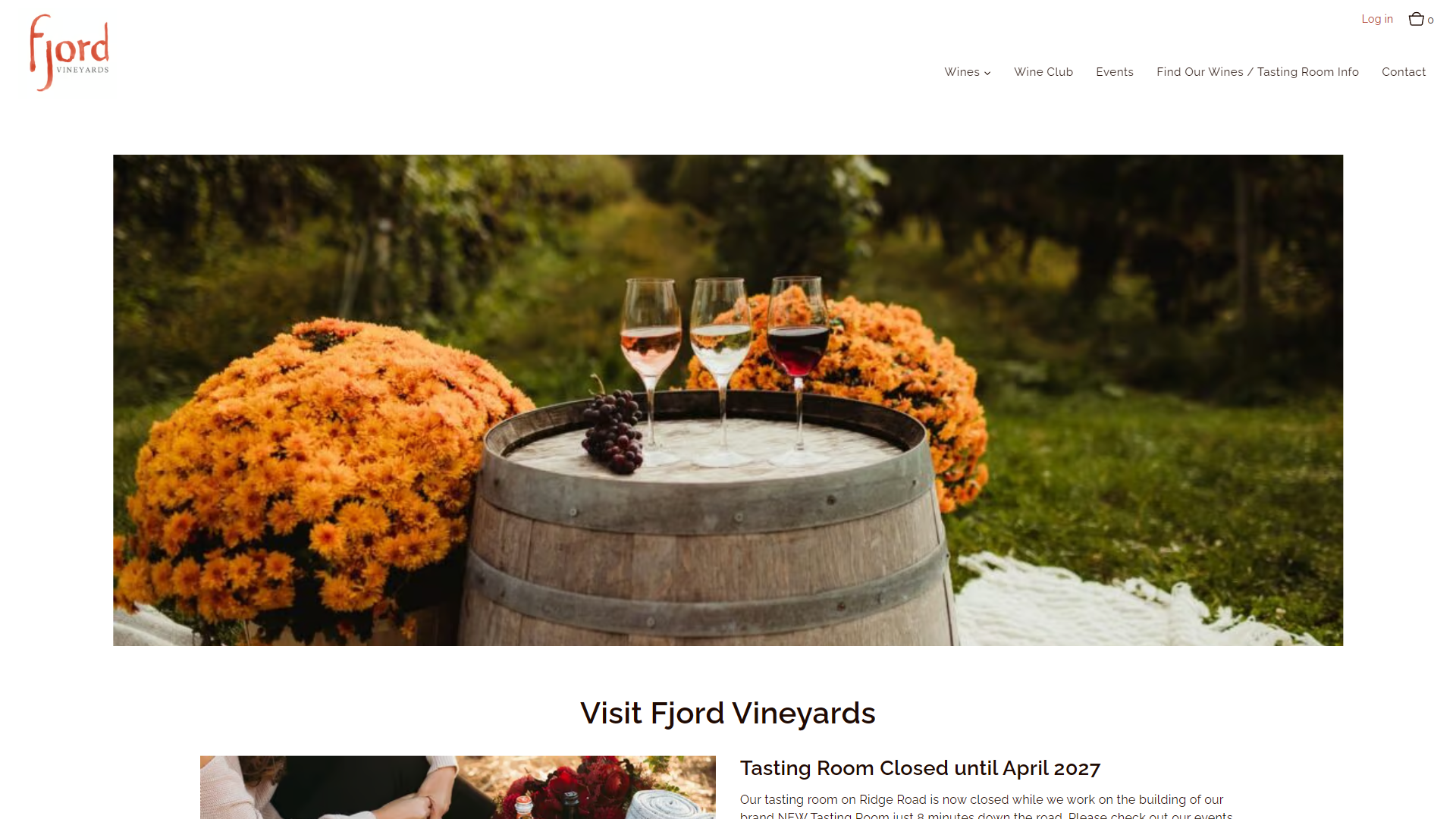The Fjord Vineyards Visit Us page in a desktop browser, with three filled glasses standing on a barrel between banks of orange chrysanthemums, above the heading "Visit Fjord Vineyards".