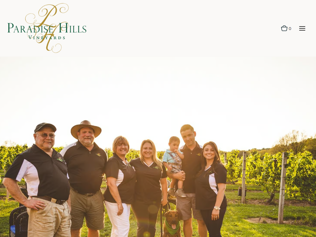The Paradise Hills family page in a desktop browser, with the family and staff photographed together in matching shirts among the vines.