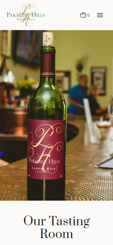 The Paradise Hills tasting room page on a phone, with the bottle on the bar above the heading "Our Tasting Room".