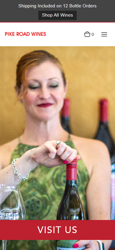 The Pike Road Wines Visit Us page on a phone, with the photograph of a woman uncorking a bottle above a red "Visit Us" panel.