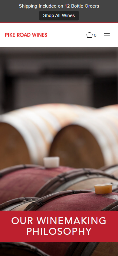 The Pike Road Wines winemaking page on a phone, showing barrels in the cellar beneath a red panel reading "Our Winemaking Philosophy".
