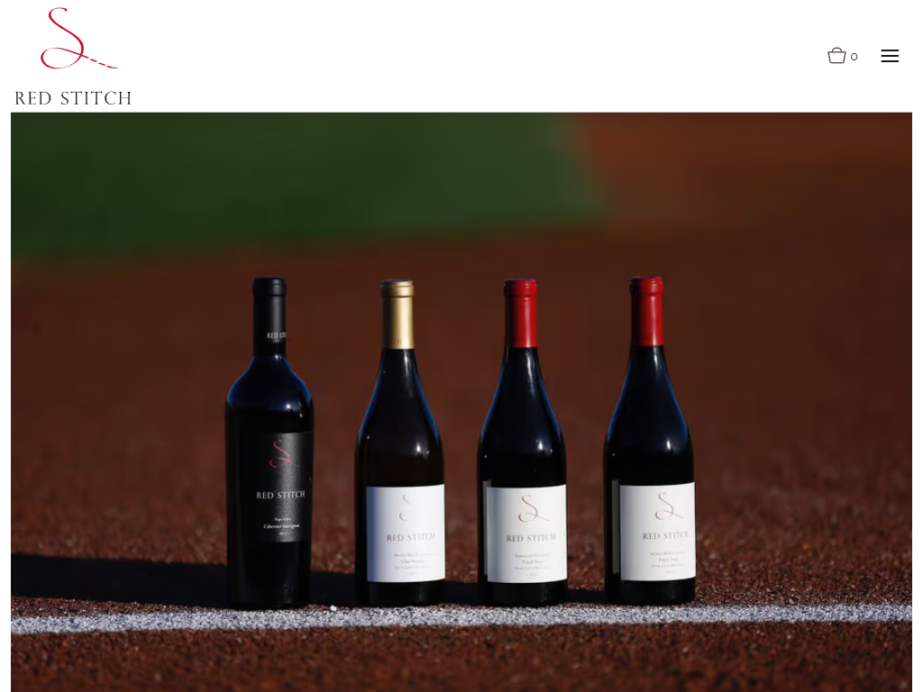 The Red Stitch story page in a desktop browser, with four bottles standing on a ledge against a deep red backdrop.