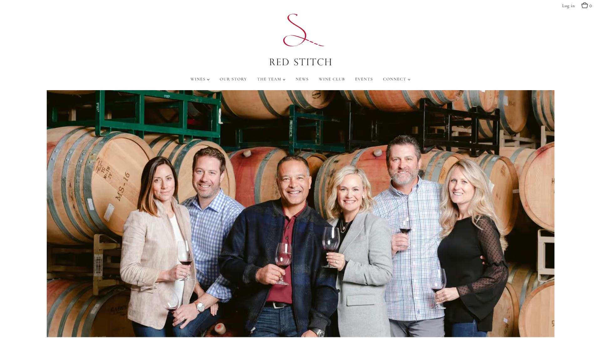 The Red Stitch team page in a desktop browser, with six members of the team holding glasses of red wine in front of stacked barrels.