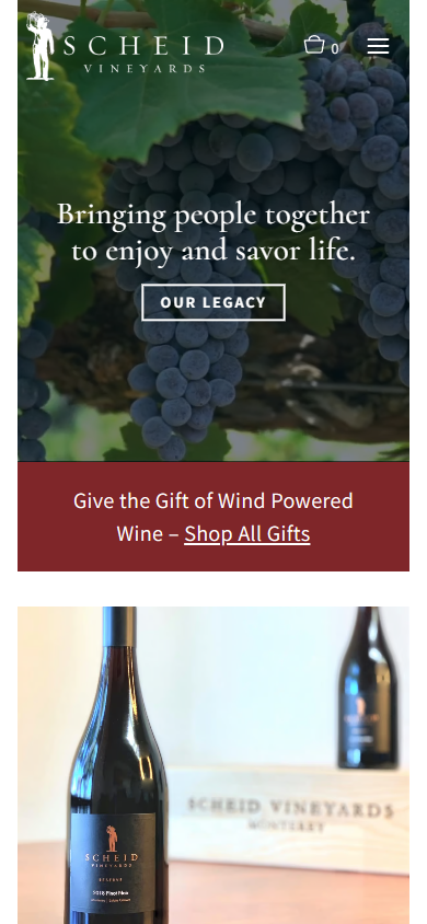 The Scheid homepage on a phone, with the tagline over the grapes, the wind-powered wine gift banner, and two bottles below.
