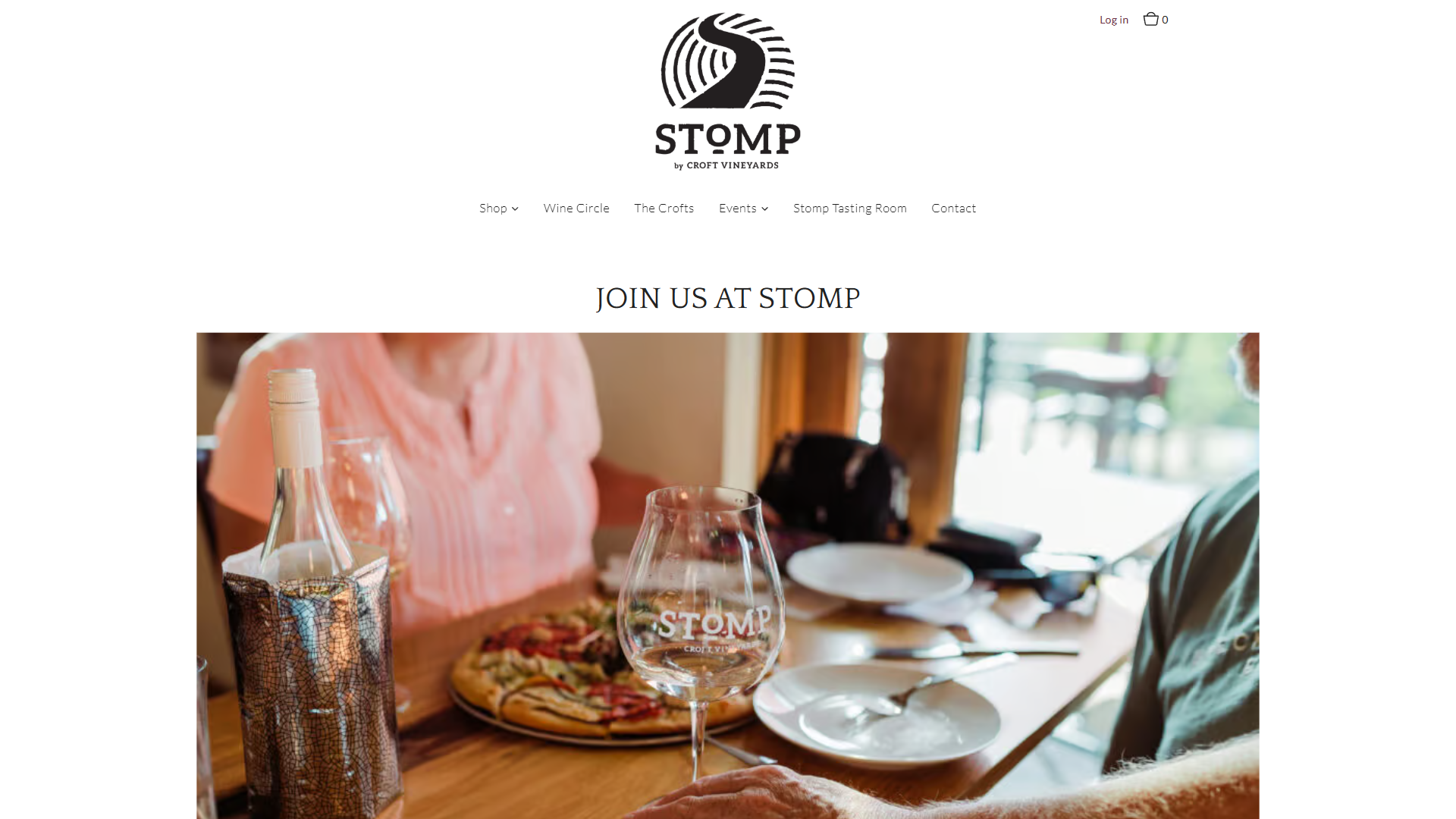 The Stomp Visit Us page in a desktop browser, headed "Join Us at Stomp", with a table set with a Stomp glass, a chilled bottle in a sleeve and a pizza.
