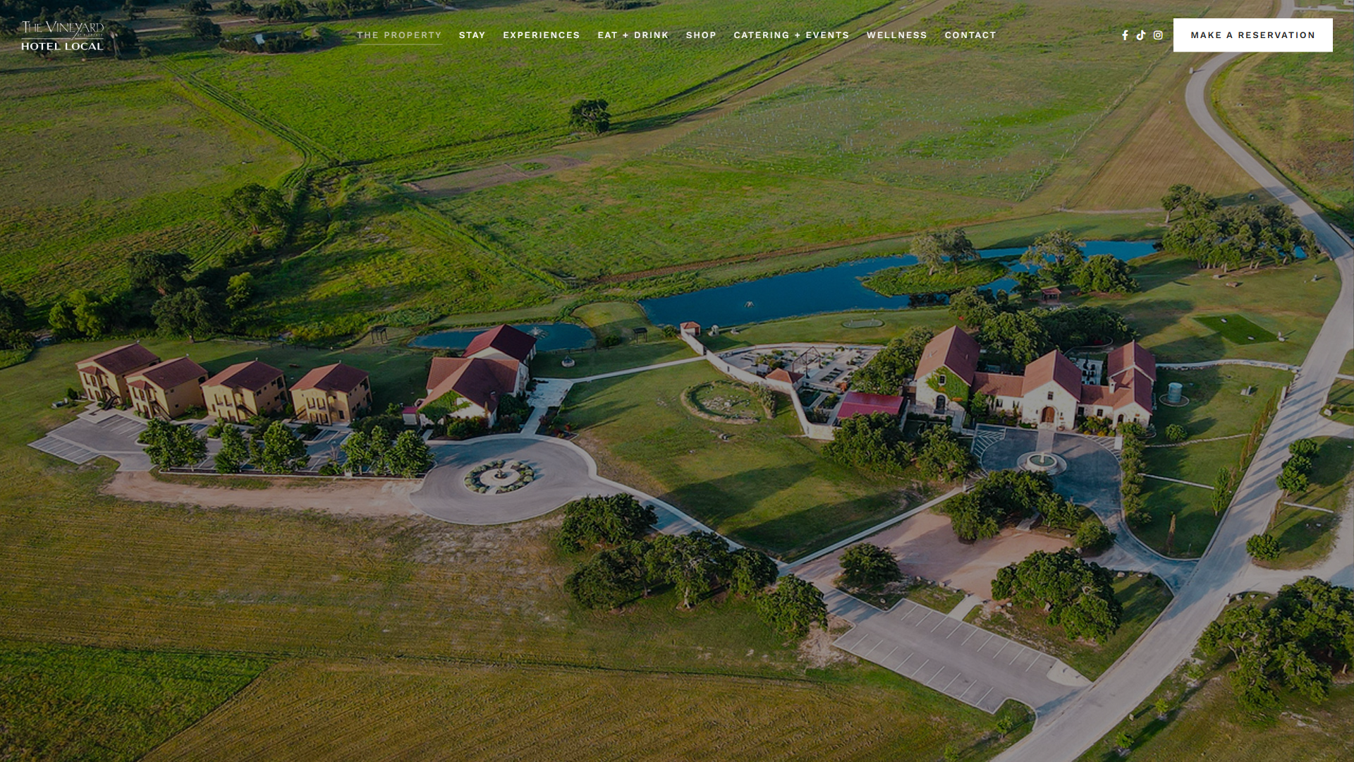 The Vineyard at Florence property page in a desktop browser, with an aerial photograph of the estate showing the tiled-roof buildings, ponds, lawns and vineyard.