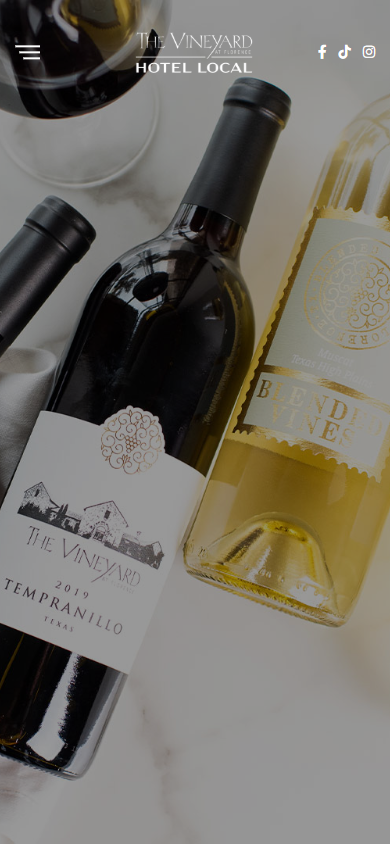 The Vineyard at Florence wine club page on a phone, with a red and a white bottle photographed together on marble.
