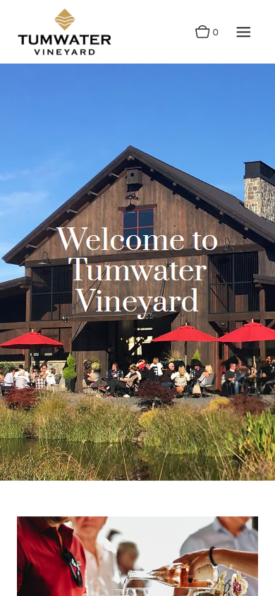 The Tumwater homepage on a phone, with the barn and red umbrellas under the heading "Welcome to Tumwater Vineyard".
