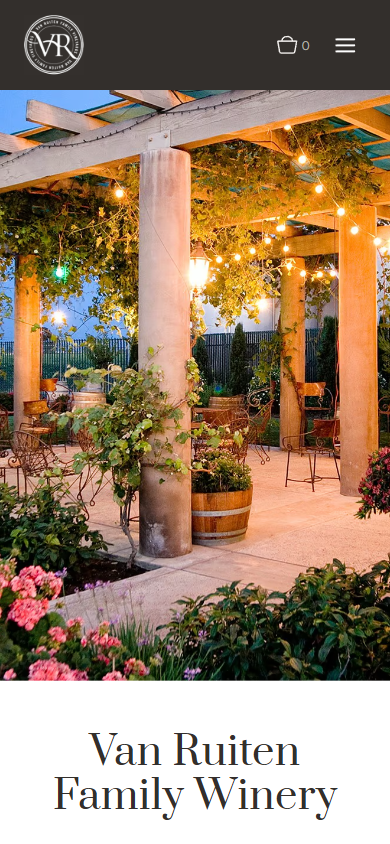 The Van Ruiten homepage on a phone, with the lit pergola and flower beds above the winery name.