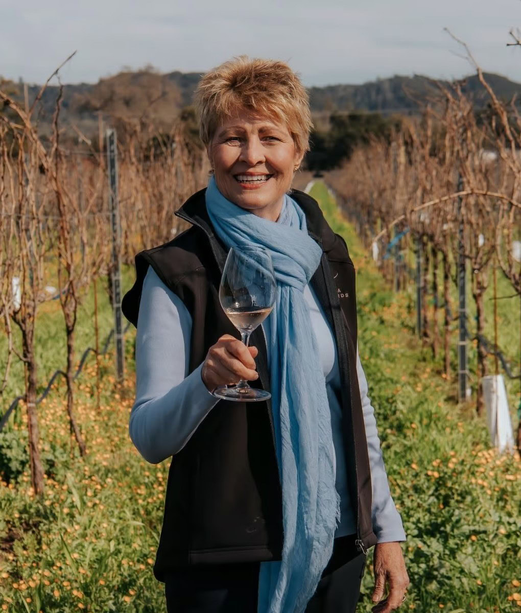 Vicky Farrow, proprietor of Amista Vineyards, in the vineyard with a glass of sparkling wine