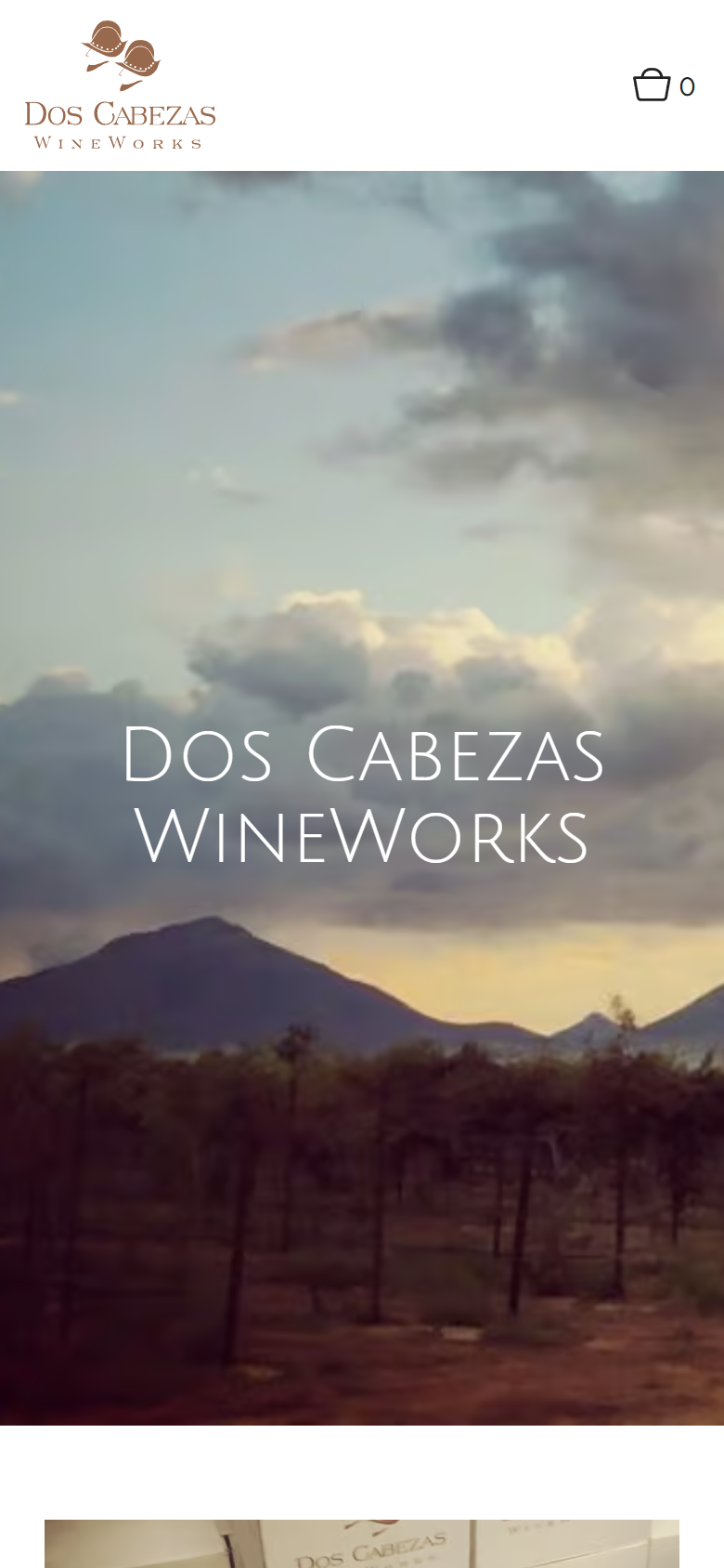 The Dos Cabezas home page on a phone: the mountains and vineyard under a cloudy sky with the winery name.