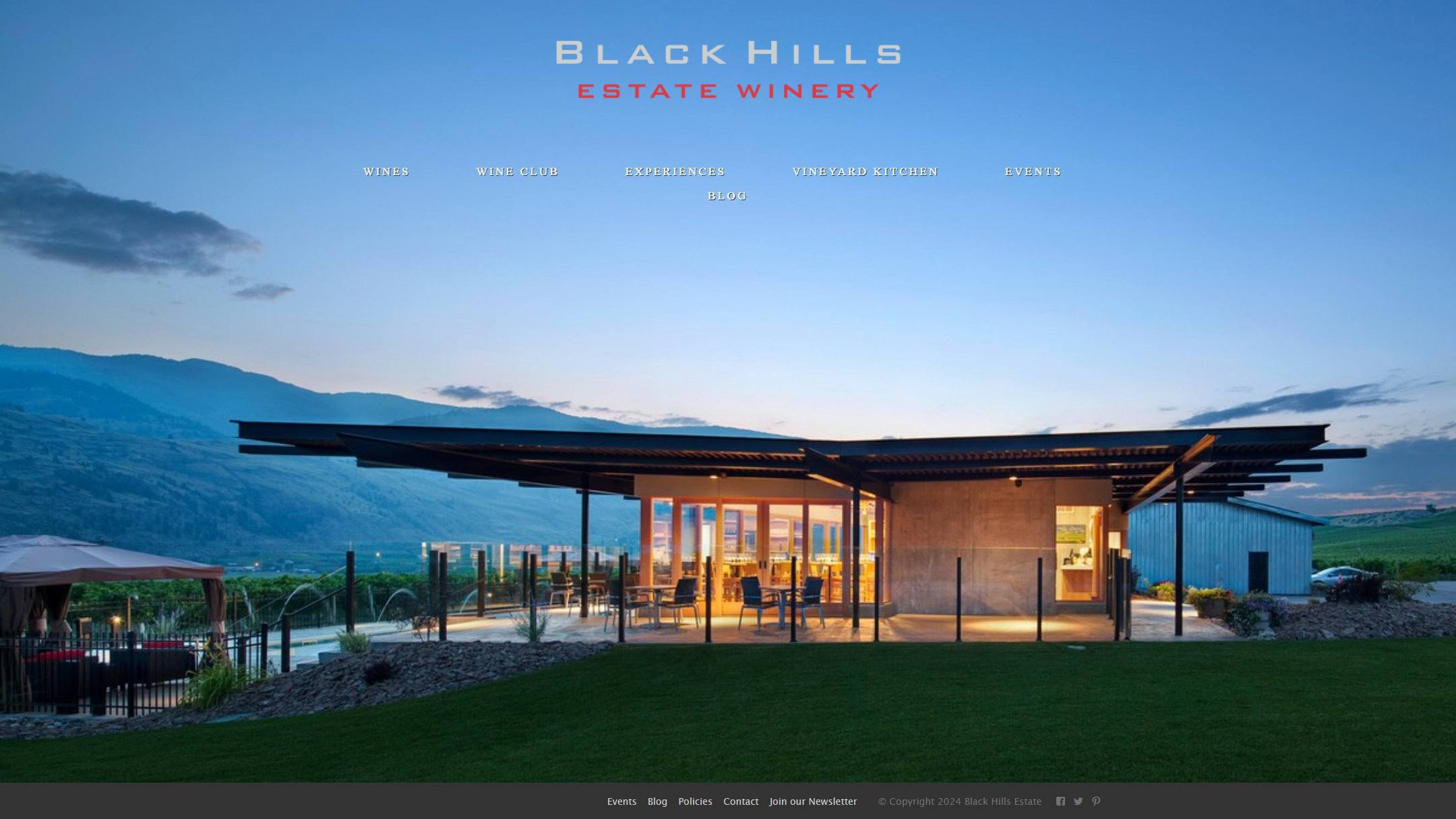 The Black Hills home page in 2024: one photograph of the winery at dusk under the logo and a menu