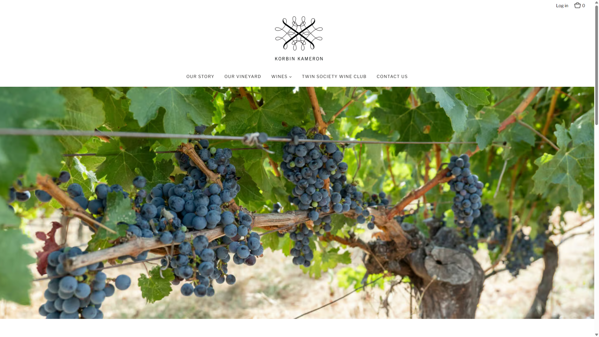 The Our Vineyard page on desktop: clusters of ripe dark grapes hanging under green leaves.